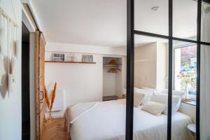 1 dormitorio con cama blanca y ventana en Charmant Studio paisible dans le Centre du Village, en Échenevex