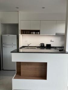 a white kitchen with a stove and a refrigerator at PELLERANO APARTMENT in Adrogué
