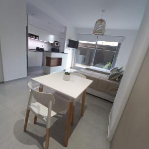 a white table and chairs in a room with a bed at PELLERANO APARTMENT in Adrogué +1 photo