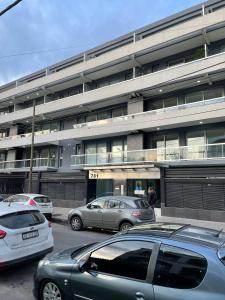 a parking lot with cars parked in front of a building at PELLERANO APARTMENT in Adrogué