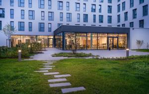 a building with a walkway in front of a building at elaya hotel augsburg in Augsburg