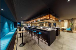 a bar in a restaurant with blue walls and stools at elaya hotel goeppingen, Trademark Collection by Wyndham in Göppingen +33 photos