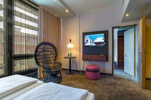 a hotel room with a bed and a tv at elaya hotel munich city in Munich