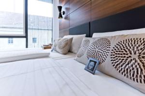 a bedroom with a bed with white sheets and pillows at elaya hotel munich city, Trademark Collection by Wyndham in Munich