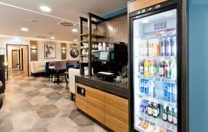 a store with a refrigerator filled with lots of drinks at elaya hotel munich city in Munich