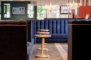 a dining room with blue chairs and a table at elaya hotel oberhausen, Trademark by Wyndham in Oberhausen