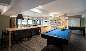 a room with a pool table and a bar at elaya hotel oberhausen ehemals ANA Living Oberhausen by Arthotel ANA in Oberhausen