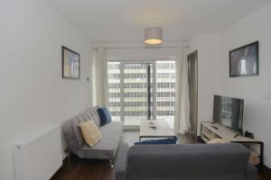 een woonkamer met een bank en een groot raam bij Amazing Central Southend,2-bedroom flat,10th floor in Southend-on-Sea
