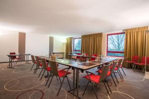 una sala de conferencias con una mesa larga y sillas en elaya hotel frankfurt oberursel, en Oberursel