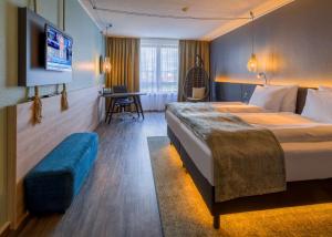 a hotel room with a large bed and a desk at elaya hotel frankfurt oberursel in Oberursel