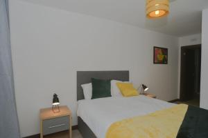 a bedroom with a bed and two tables with lamps at Amazing Central Southend,2-bedroom flat,10th floor in Southend-on-Sea