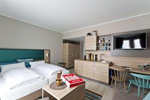 ベーブリンゲンにあるANA Living Stuttgart by Arthotel ANAのベッド、デスク、キッチンが備わるホテルルームです。