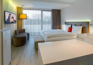 une chambre d'hôtel avec un lit et une chaise dans l'établissement elaya hotel kleve, à Clèves