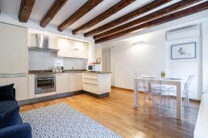 una cucina e un soggiorno con tavolo e sedie di Ca' Laura - San Marco Canal View a Venezia
