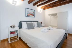 una camera da letto con un grande letto bianco con asciugamani di Ca' Laura - San Marco Canal View a Venezia