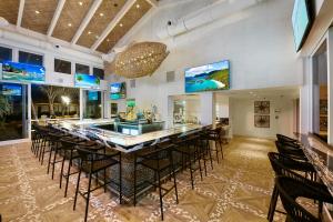 a bar in a room with a long table and chairs at Beachcomber Resort & Club in Pompano Beach