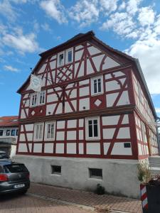 a half timberedbered house with red and white at Apartments & möblierte Zimmer in Kahl am Main, kontaktloser Self Check-in, W-Lan, Schreibtisch, Duschbad, Küchenzeile, PKW-Plätze in Kahl am Main