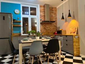 a kitchen with a table and chairs in it at Apartament przy Ratuszu in Barczewo