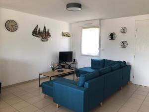 salon z niebieską kanapą i stołem w obiekcie Maison plein pied sur les hauteurs de Fécamp w mieście Fécamp +5 zdjęć