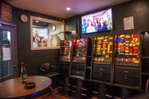 a room with slot machines and a table and a tv at Hotel Amager in Copenhagen