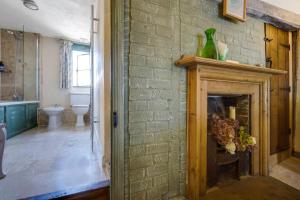 a bathroom with a brick wall with a fireplace at The Tea House in Rye +37 photos