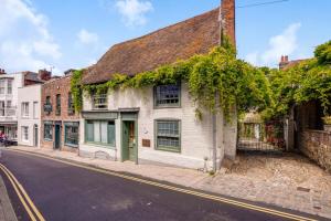 an old white building with green doors on a street at The Tea House in Rye