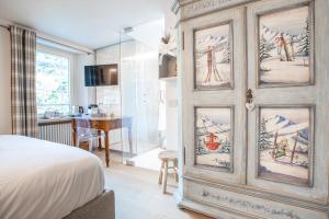 a bedroom with a large wooden cabinet with paintings on it at MAISON IDA in Courmayeur