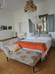 a bedroom with a large bed and a couch at B&B LaMaGia di Corte Moronati in Sirmione