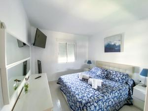 a white bedroom with a bed and a white desk at Bellaluz 18.15, La Manga Club Resort in Atamaría