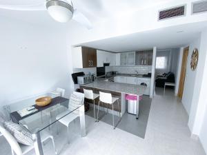 a kitchen and living room with a table and chairs at Bellaluz 18.15, La Manga Club Resort in Atamaría