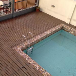 una piscina con una silla en medio de una terraza en Edificio San Juan de Buenos Aires. en Buenos Aires