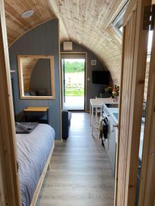 a small room with a bed and a table and a kitchen at Mowbray Cottages & Glamping in South Kilvington