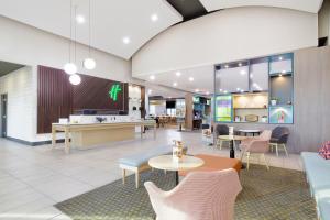 a lobby with tables and chairs in a cafeteria at Holiday Inn Phoenix Airport, an IHG Hotel in Phoenix