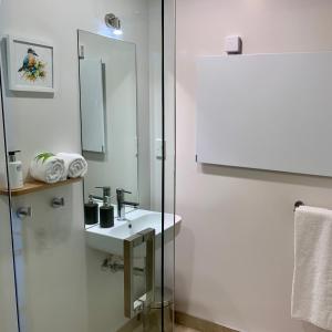 uma casa de banho branca com um lavatório e um espelho em Kaiteriteri Ridge Holiday Estate em Kaiteriteri