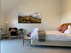 a bedroom with a bed and a painting on the wall at Kaiteriteri Ridge Holiday Estate in Kaiteriteri