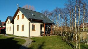 a small white house with a black roof at Wiatr i Woda Jastarnia in Jastarnia