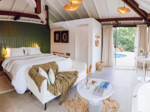1 dormitorio con 1 cama grande y 1 mesa en Naatooh Guest Houses, en Florianópolis