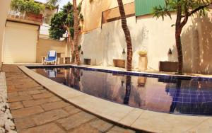 a swimming pool next to a building with palm trees at The Villa In Lavinia in Mount Lavinia