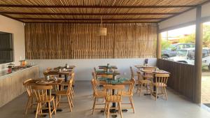une salle à manger avec des tables et des chaises en bois dans l'établissement Pousada Sela Gineta, à Fernando de Noronha