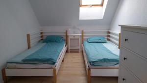 2 łóżka pojedyncze w niewielkim pokoju z oknem w obiekcie Wiatr i Woda Jastarnia w Jastarni