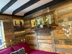 1 dormitorio con paredes de madera y 1 cama con sábanas moradas en Yarm cottages haystacks/hayloft, en Kirk Leavington
