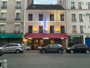 un grupo de coches estacionados frente a un edificio en Hôtel Léonard de Vinci II en París