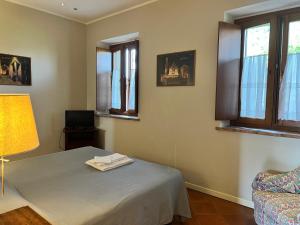 a bedroom with a bed and a lamp and windows at Agriturismo Cascina Nuova in Cremona