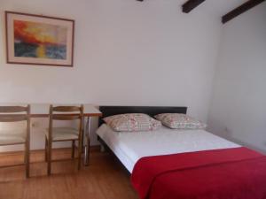 ein Schlafzimmer mit einem Bett, einem Schreibtisch und einem Stuhl in der Unterkunft Apartments Ivanka Bilo in Primošten