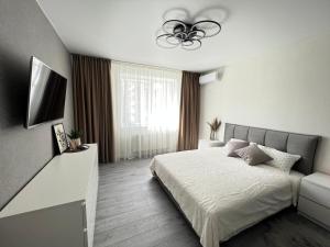 een slaapkamer met een bed en een plafondventilator bij Квартира Люкс на Поділлі in Vinnytsya
