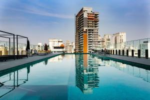 a swimming pool in a city with a tall building at VN Capote Valente 712 no coração de São Paulo in Sao Paulo