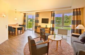 ein Wohnzimmer mit einem Sofa und einem Tisch in der Unterkunft Gut Heckenhof Hotel & Golfresort an der Sieg GmbH & Co. KG in Eitorf