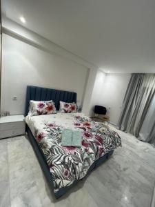 une chambre avec un grand lit et une tête de lit bleue dans l'établissement PALACE B Av Hassan II Marrakech 40000-Specious UNIT#7, à Marrakech