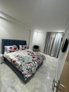 - une chambre avec un grand lit et une télévision dans l'établissement PALACE B Av Hassan II Marrakech 40000-Specious UNIT#7, à Marrakech