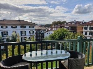 a table and chairs on a balcony with buildings at Luminoso piso con terraza y aparcamiento ESS01636 in Hondarribia